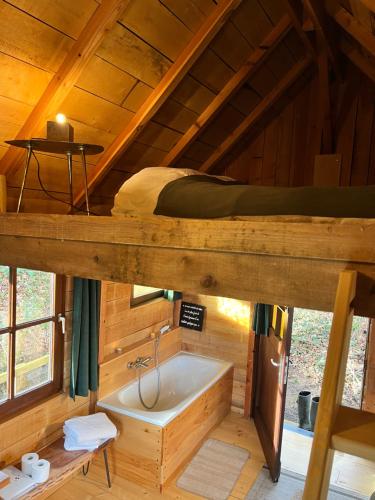a bathroom with a bed and a tub in a cabin at Cabane du Voyageur in Yvoir