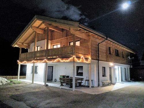 a house with a balcony on top of it at night at Apartments Haufhof , Haus im Ennstal bei Schladming in Haus im Ennstal