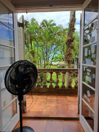 a door open to a balcony with a fan at Casa Pé na Areia Cantão do Bora Bora - Manaaki Surf Hostel in São Sebastião