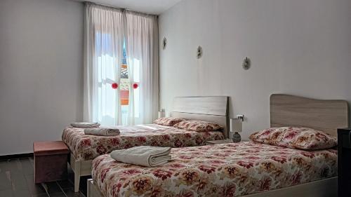 Casa vacanze da Linda في Pignola: غرفة نوم بسريرين ونافذة