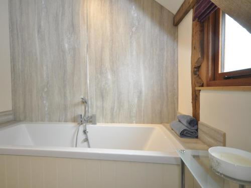 a white bath tub in a bathroom with a sink at 3 Bed in Leominster 50507 in Pencombe