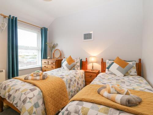 1 dormitorio con 2 camas individuales y ventana en Bythynnod Newydd, en Trevor