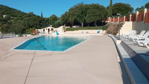 une piscine avec des chaises à côté d'un bâtiment dans l'établissement Le Bungalow Bleu Domaine des Canebieres Golfe de St Tropez, au Muy