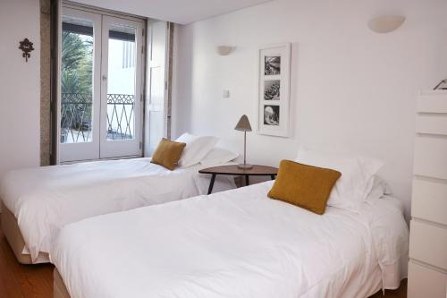 ポルトにあるChillHouse_Portoの窓付きの客室で、白いベッド2台が備わります。