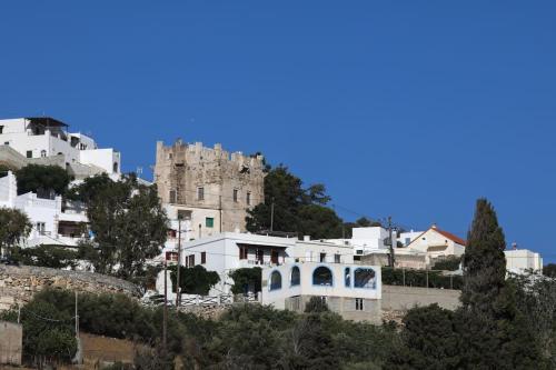 um grupo de edifícios brancos numa colina com um castelo em Tower of Dellarokas em Mélanes
