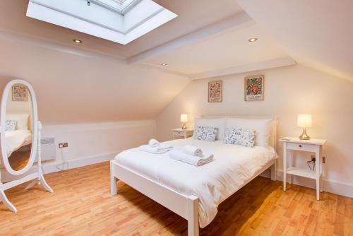a bedroom with a white bed and a skylight at Wonderful Two-Bedroom Apartment in London