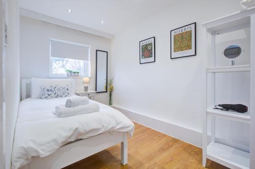 a white bedroom with a bed and a window at Wonderful Two-Bedroom Apartment in London