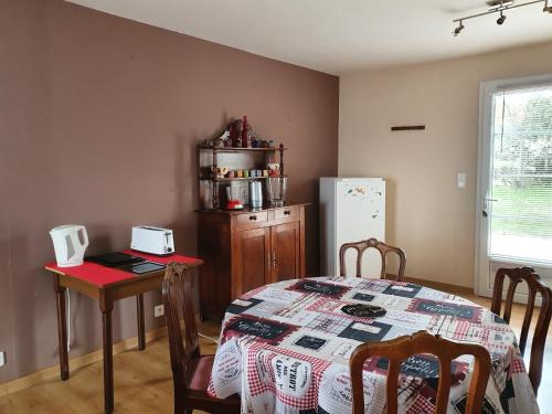 une salle à manger avec une table et un réfrigérateur dans l'établissement Les contemplations, à Barjac