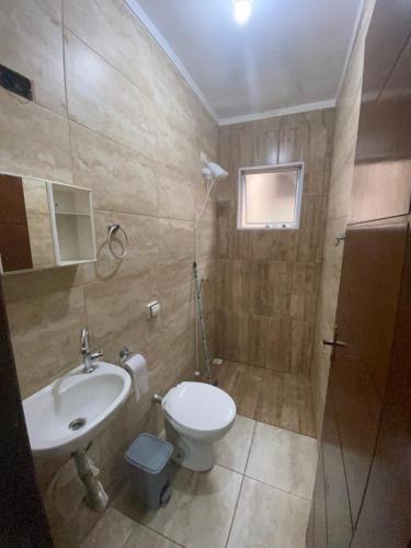 a bathroom with a toilet and a sink at Casa Praia Temporada Itanhaém in Itanhaém