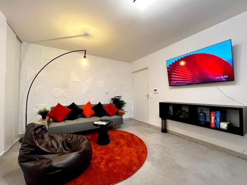 ein Wohnzimmer mit einem Sofa und einem Fernseher an der Wand in der Unterkunft Dream Suite Signature in Chessy