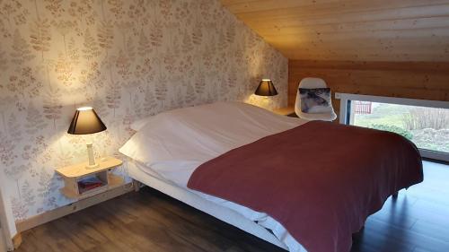a bedroom with a bed with two lamps and a chair at CHALET L'ÉCHAPPÉE NATURE 4 étoiles sauna in Anould