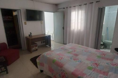 a bedroom with a bed and a dresser in it at casa da Déa in Mogi das Cruzes