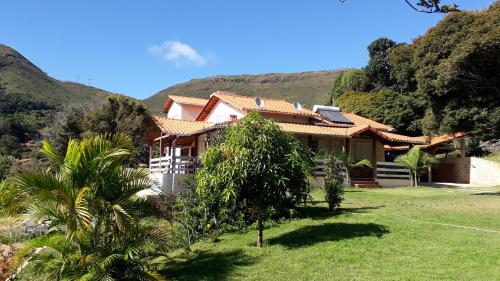 a house with a mountain in the background at Sítio da Serra em Ouro Preto MG in Cachoeira do Campo