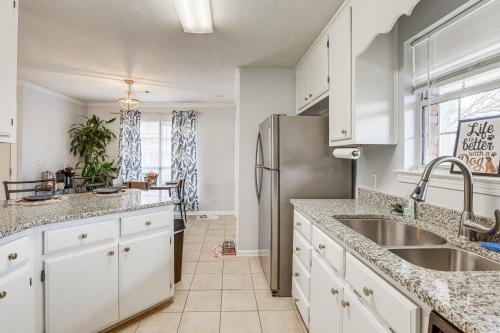 a kitchen with white cabinets and a stainless steel refrigerator at Pet-Friendly Millbrook Home with Covered Patio! in Millbrook