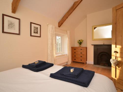 a bedroom with two towels on a bed with a fireplace at 2 bed property in Ilminster Somerset 56523 in Ilminster