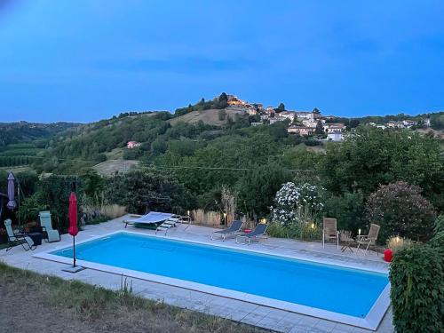 uma piscina com uma montanha ao fundo em Villa Bricco Astiani em Montegrosso dʼAsti