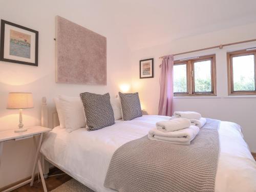 a bedroom with a bed with towels on it at The Nook in Halesworth