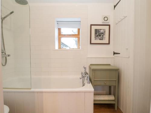 a bathroom with a shower and a tub and a sink at The Nook in Halesworth