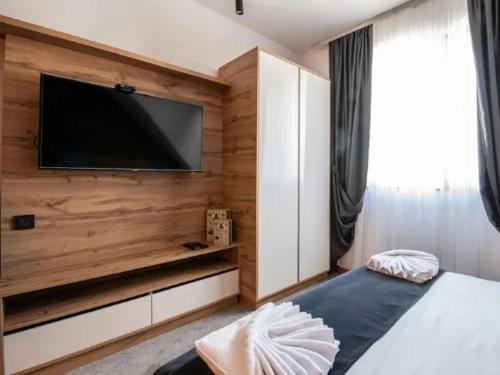 a bedroom with a flat screen tv on a wooden wall at Lux studio Andrej A43 Hotel Djina in Kopaonik