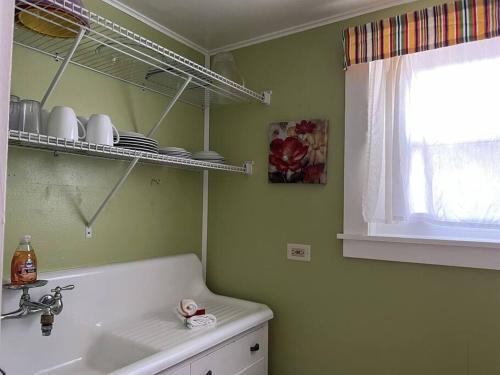 a bathroom with a sink and a window and a shelf at Cottage 8-9 - Stand Alone 2 Bedroom / 2 Bath in Wolfeboro