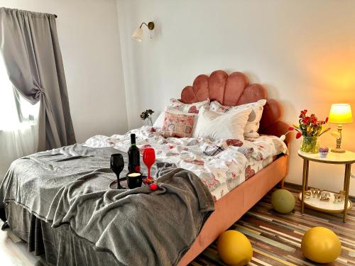 a bedroom with a bed with wine bottles and glasses at Pensiunea Grădina Ascunsa in Bughea de Jos