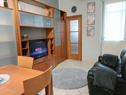 LELLO'S HOUSE في تورينو: غرفة معيشة مع تلفزيون وطاولة