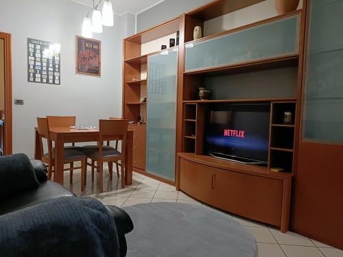 LELLO'S HOUSE في تورينو: غرفة معيشة مع تلفزيون وطاولة طعام