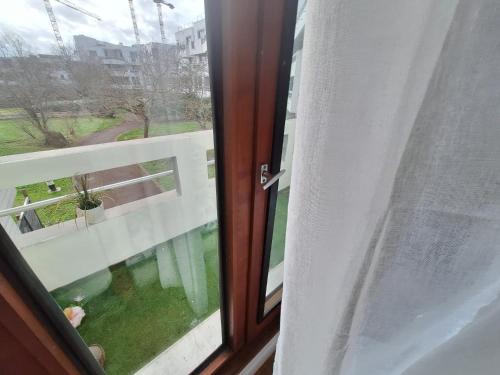 une fenêtre ouverte avec vue sur un balcon dans l'établissement MERVEILLE APP, à Suresnes