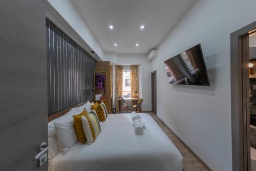 a bedroom with a large bed with yellow pillows at Cola Suites Apartments in Rome