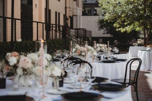 a table set up for a wedding with flowers and glasses at The Guild Hotel San Diego Downtown, a Marriott Tribute Portfolio Hotel in San Diego