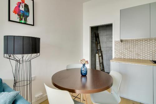 un salon avec une table en bois et des chaises blanches dans l'établissement 176 Suite Jean - Superb apartment in Paris, à Paris