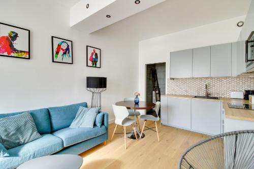 un salon avec un canapé bleu et une cuisine dans l'établissement 176 Suite Jean - Superb apartment in Paris, à Paris