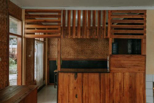 cocina con armarios de madera y encimera de madera en Villa Situ Patenggang, en Ciwidey