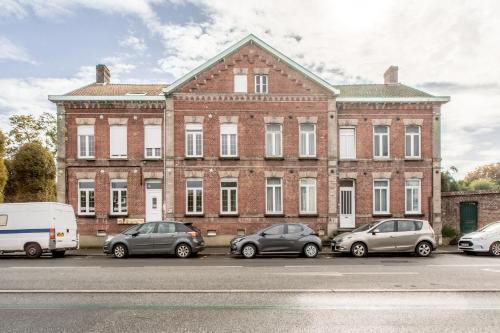 a large brick building with cars parked in front of it at La Maison Jaurès - L'Ethnique in Liévin