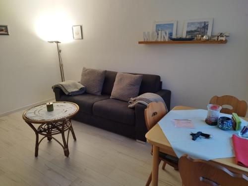 ein Wohnzimmer mit einem Sofa und einem Tisch in der Unterkunft Strandperle in Westerland