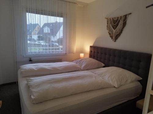 2 Betten in einem Schlafzimmer mit Fenster in der Unterkunft Strandperle in Westerland