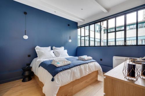 1 dormitorio azul con 1 cama con pared azul en 178 Suite Cesar - Superb apartment in Paris en París