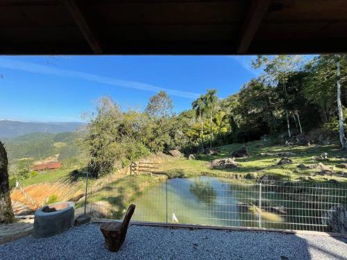 a balcony with a view of a pond and trees at Recanto Nascer do Sol in Aguas Mornas