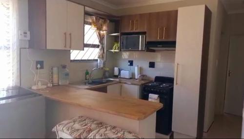 a kitchen with a wooden counter top in a room at TALITHA'S SELF-CATERING ACCOMMODATION in Walvis Bay