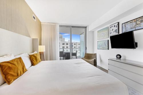a bedroom with a large bed and a tv at Ocean View Balcony with Pool Gym Access in Hallandale Beach