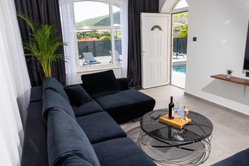 un soggiorno con divano blu e tavolo in vetro di Villa Nono a Dubrovnik
