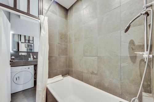 Das Bad ist mit einer Badewanne und einer Dusche ausgestattet. in der Unterkunft 113 Suite Lui - Bel Appartement à Paris in Paris