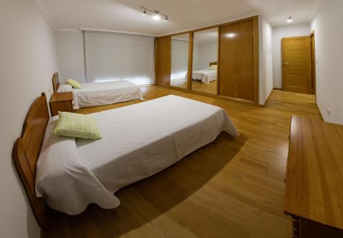 een grote slaapkamer met 2 bedden en een spiegel bij Vacaciones en O Grove in O Grove