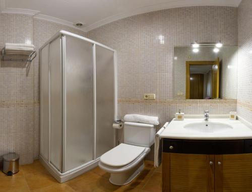 een badkamer met een douche, een toilet en een wastafel bij Vacaciones en O Grove in O Grove