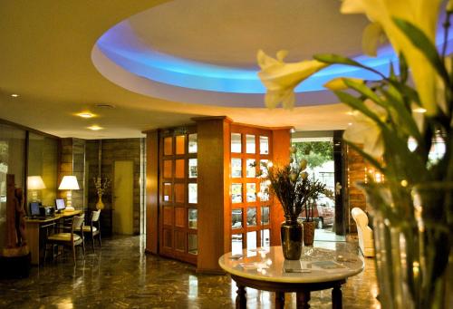 a lobby with a table and a blue ceiling at Hotel Mayoral in Rosario