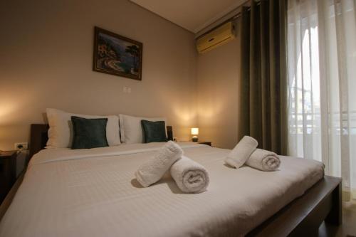 um quarto com uma grande cama branca com toalhas em Johan's Apartment em Tirana