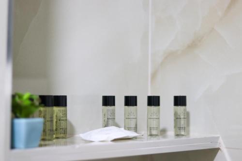 uma prateleira com quatro garrafas de cosméticos em Johan's Apartment em Tirana