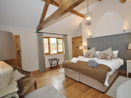 a bedroom with a large bed and a chair at 2 Bed in Leominster 50518 in Pencombe