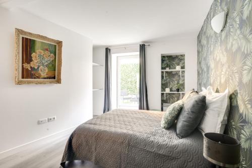 a white bedroom with a bed and a window at 801 Suite Luxurys - Superbe Appartement in Bagnolet