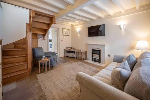 a living room with a couch and a fireplace at Pebbles Cottage, Southwold in Southwold